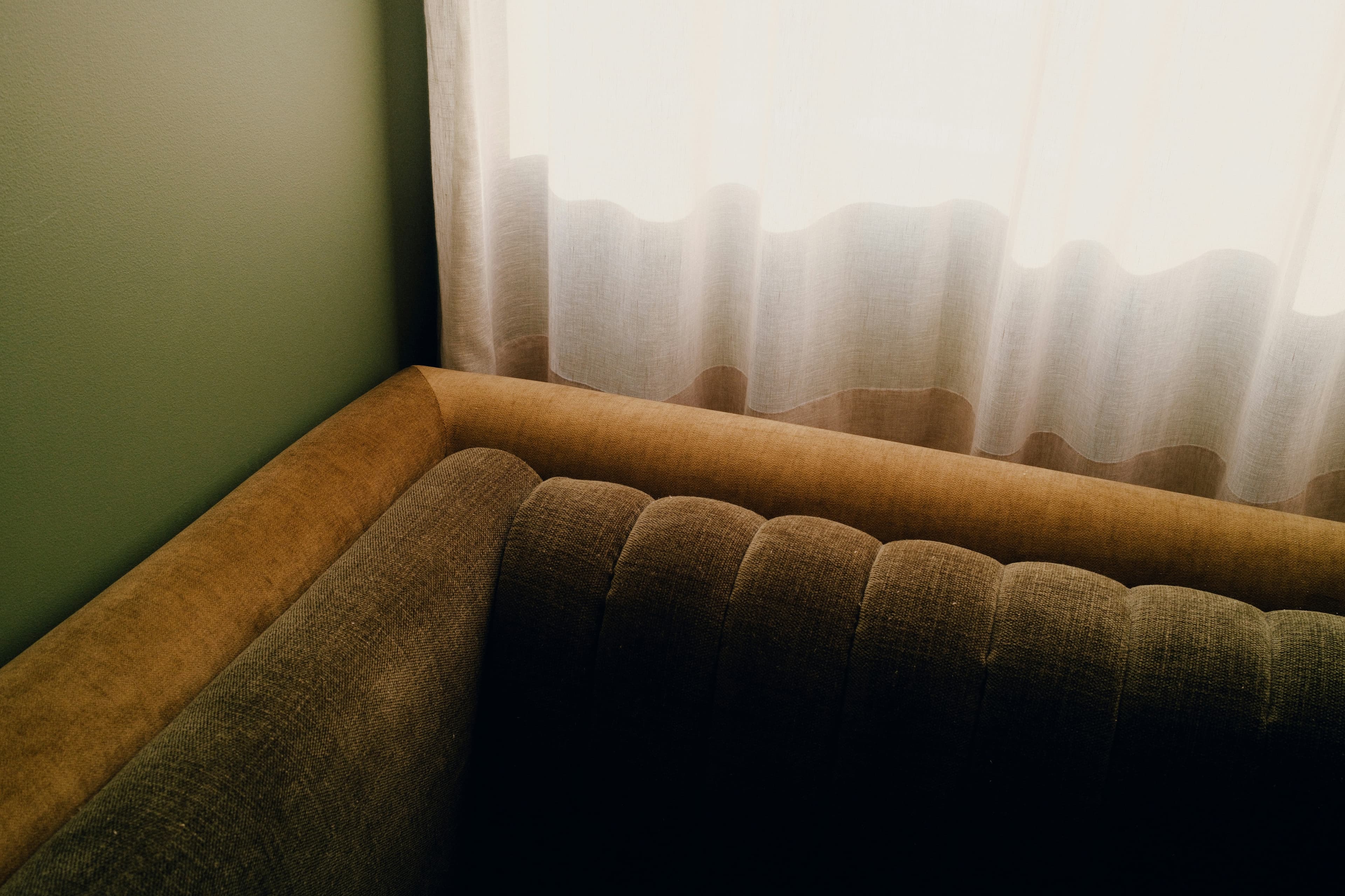 Green lounge chair beside a window