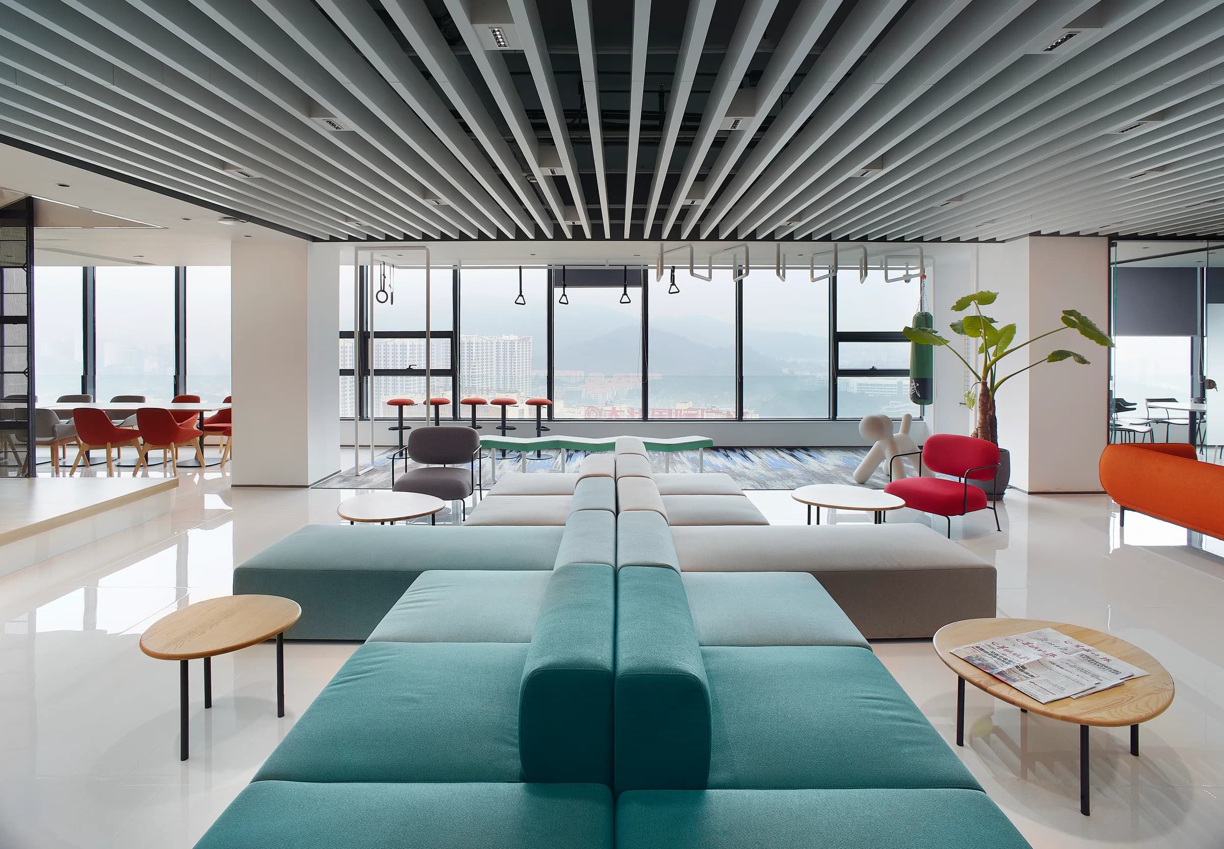 Open workplace lounge with modular blue seating and city views