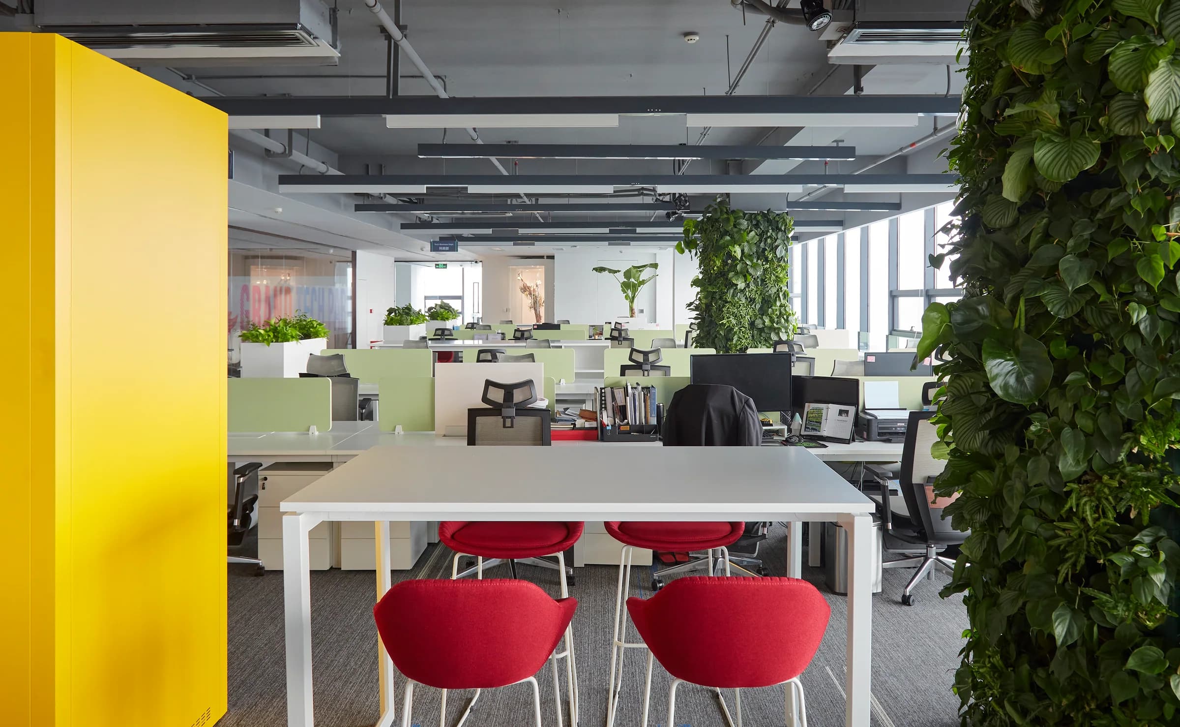 Open workplace with integrated planting and colorful collaboration seating