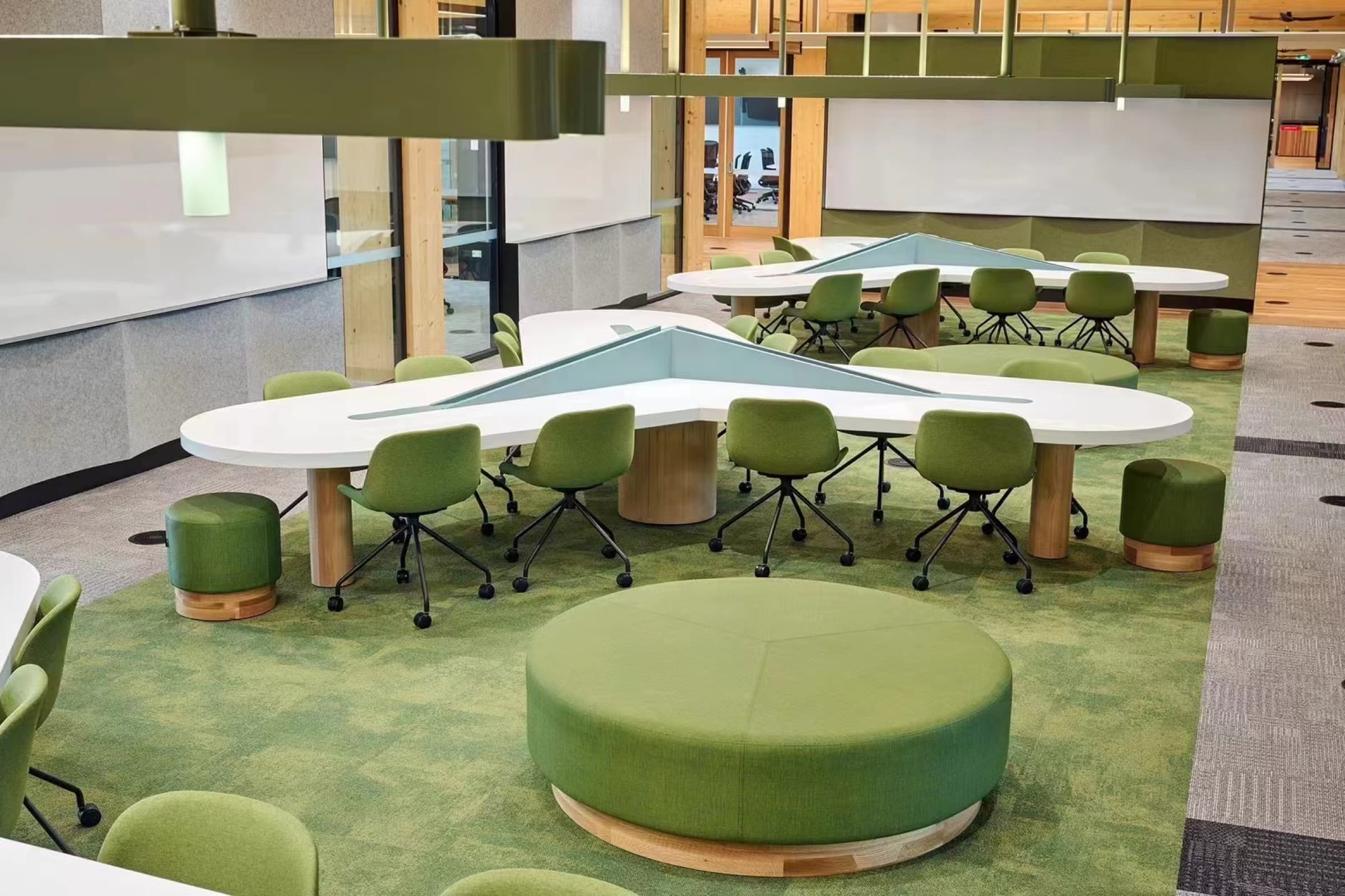 Green mobile chairs and curved tables in a flexible university study zone