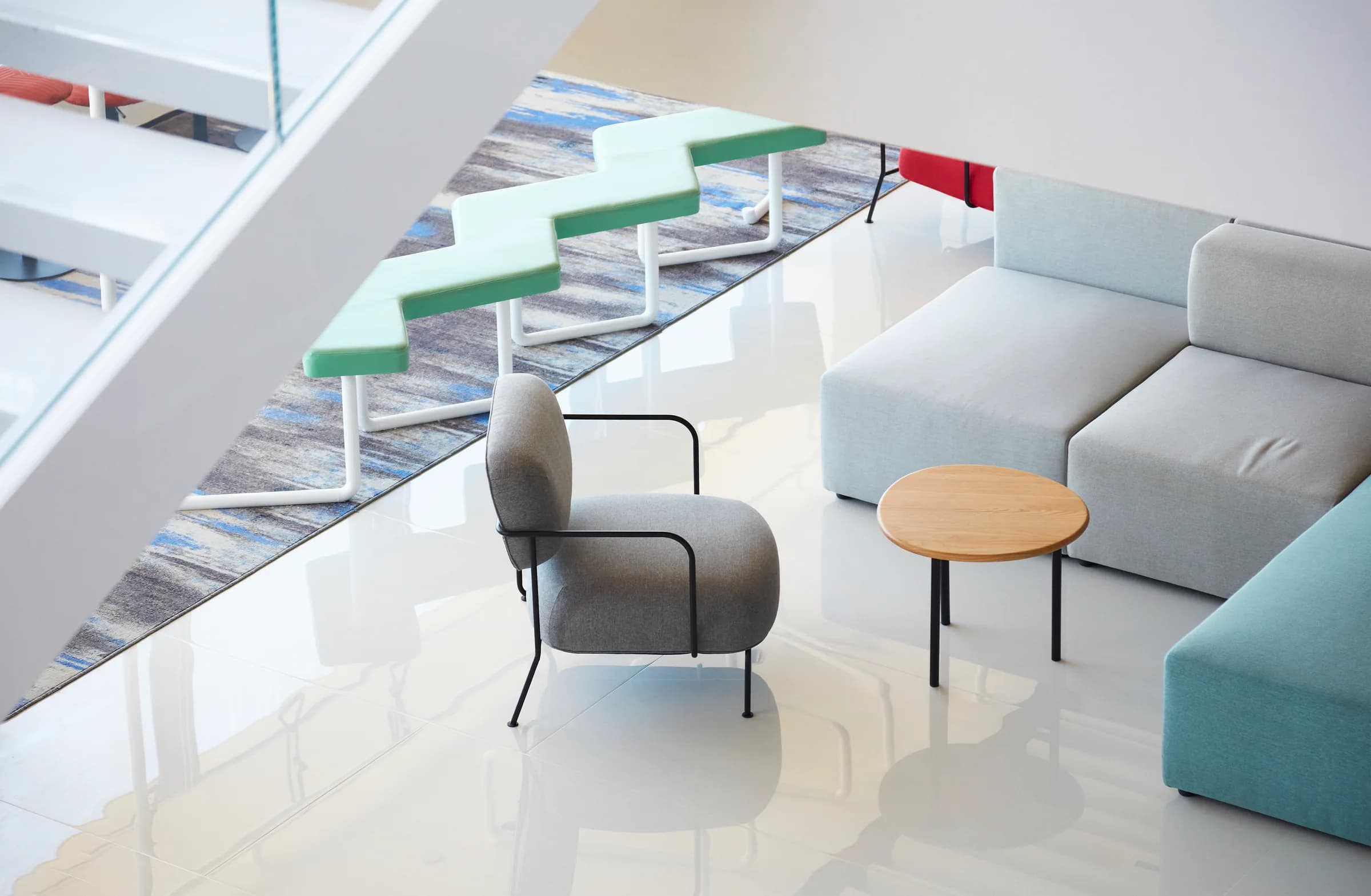 Lobby corner with lounge seating and colorful stair stools