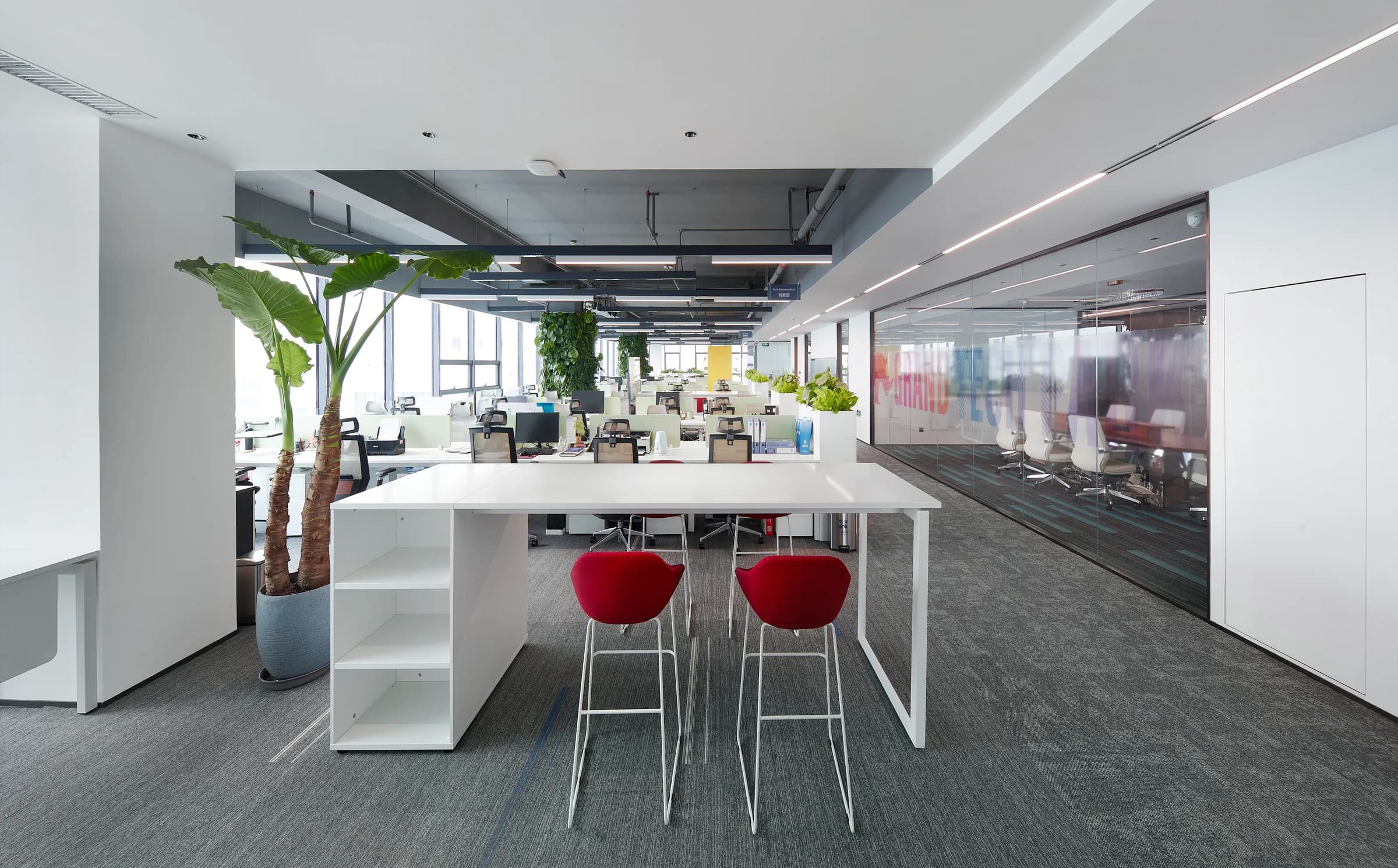 Open meeting station with planting, white surfaces, and red seating