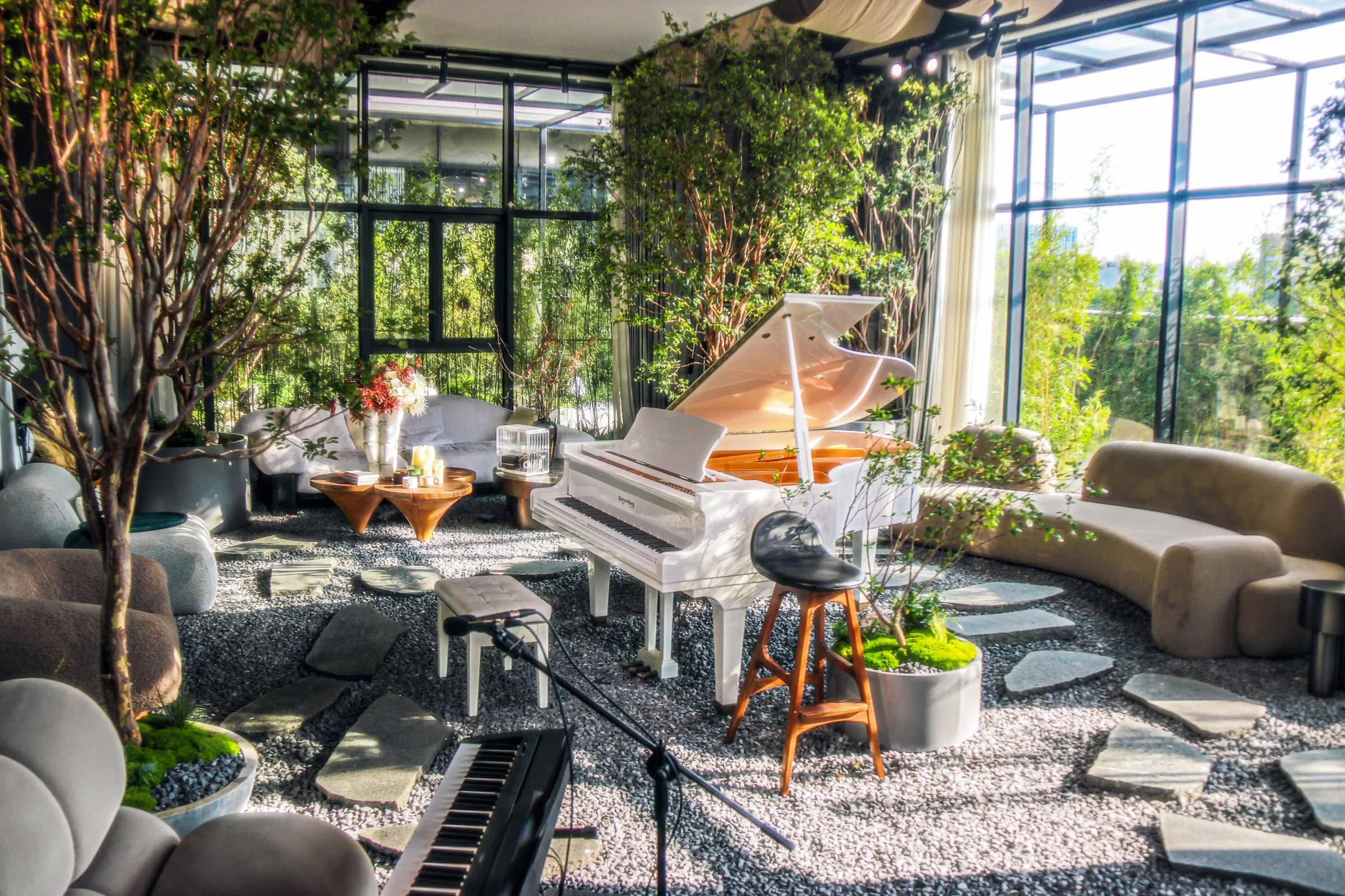 Music hall filled with indoor trees, greenery, and instruments