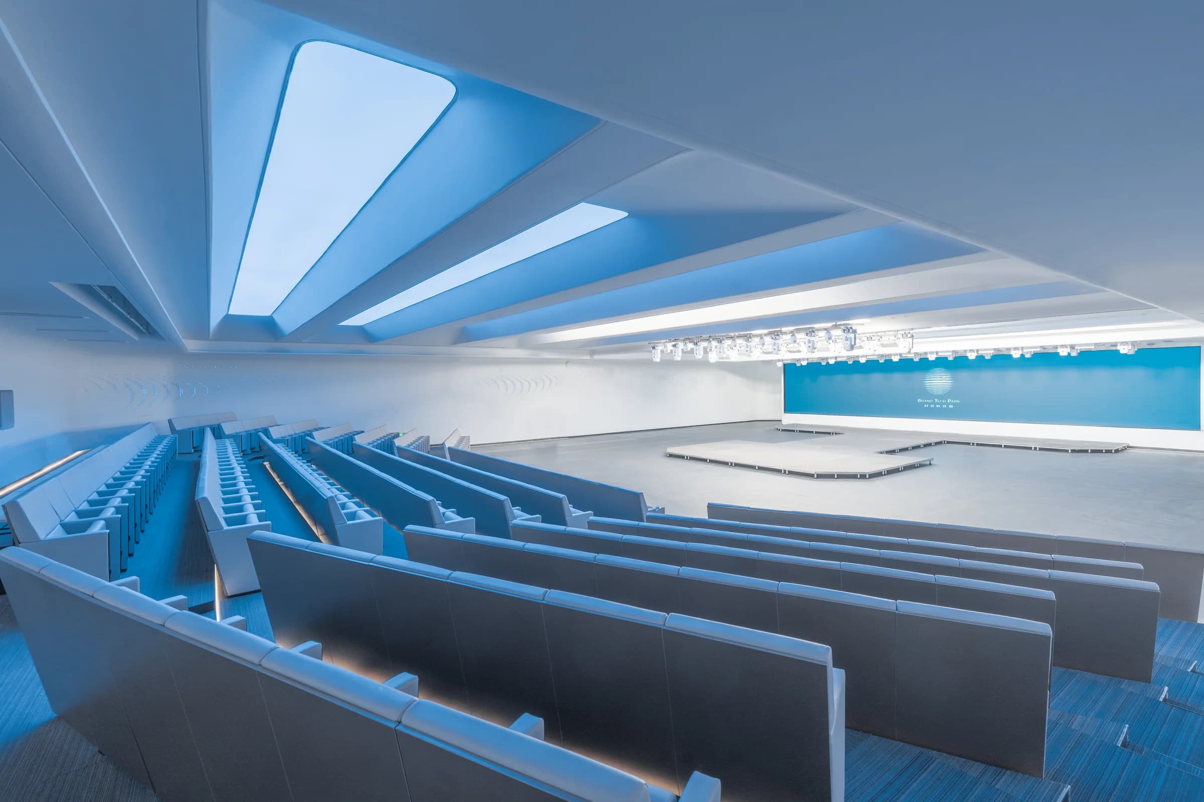 Large theater with rows of warm wood seating at Grand Tech Park